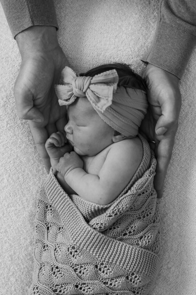 sleeping newborn baby in dads hands