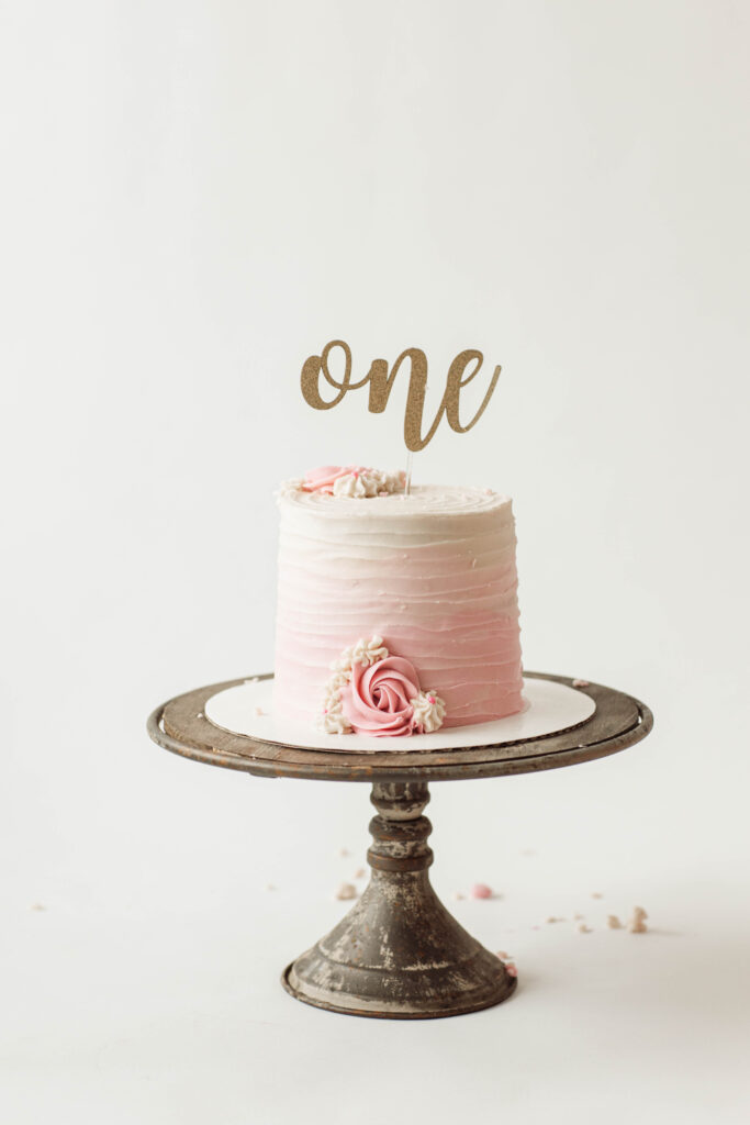 beautiful one year old pink ombre cake with "one" cake topper